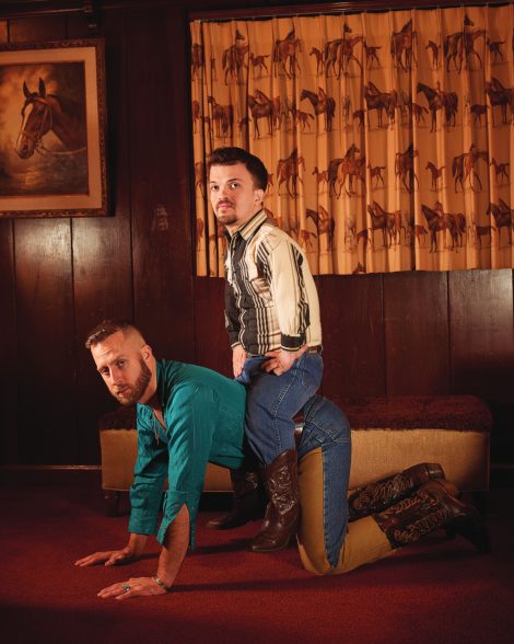 A man on all fours with another man seated atop of him
